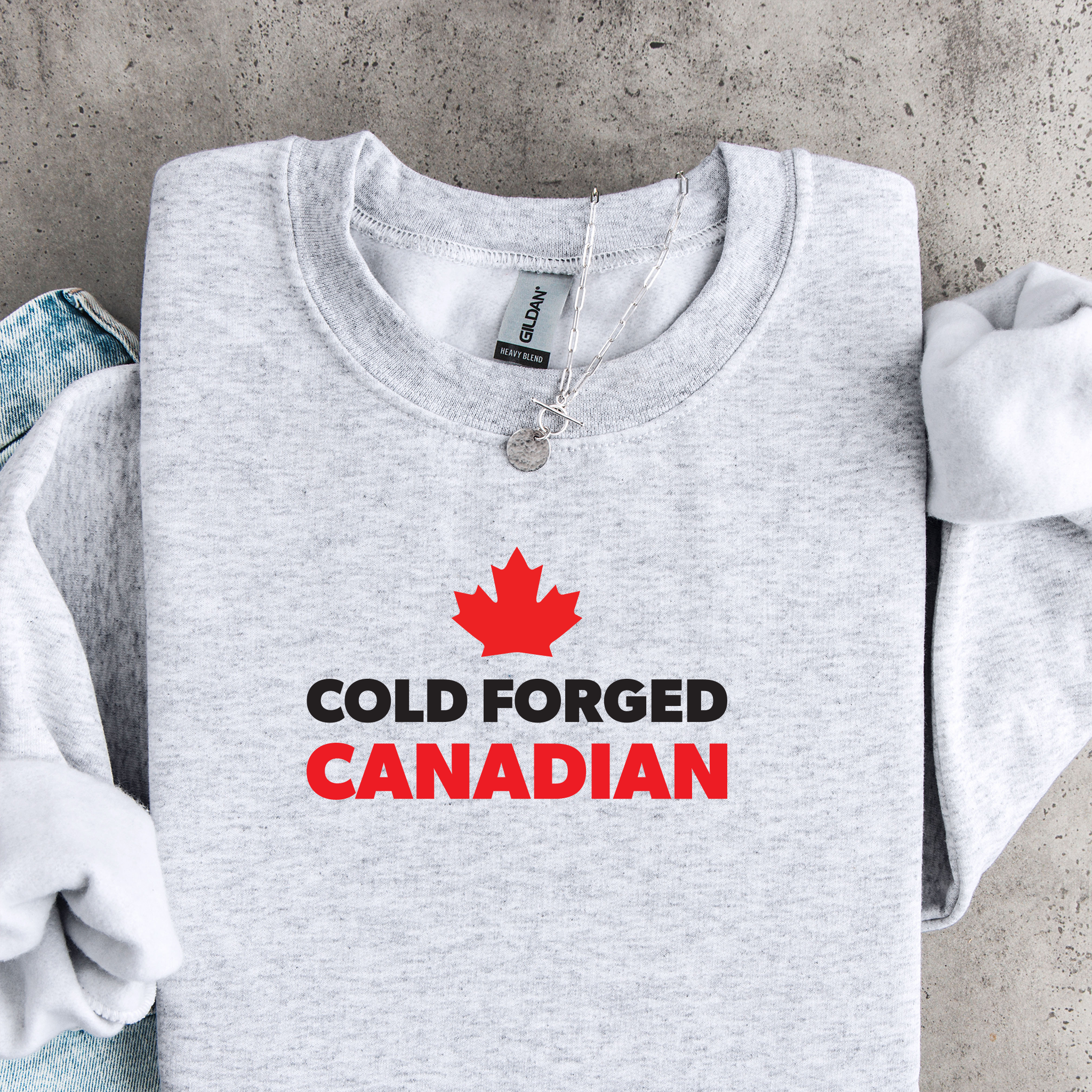 'Cold Forged Canadian' text and red maple leaf on an ash grey sweatshirt